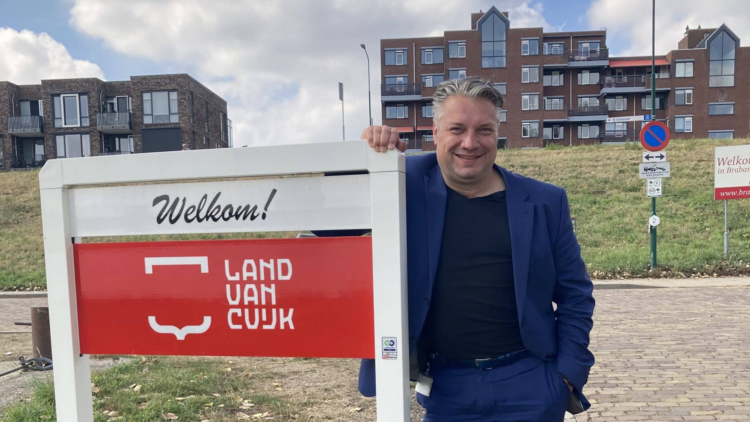 Tonnie van Doorn staat naast het bord Welkom in Land van Cuijk